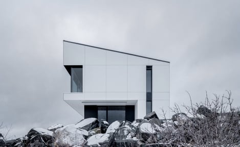 Shift house in Canada using white exterior phenolic panels and a concealed fastener.