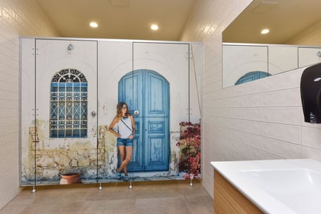 Custom HPL bathroom partition with woman leaning against a door