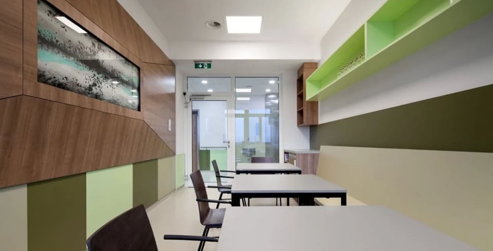 Interior wall lining of of Wilhelminenspital Medical Institute in green near tables and chairs