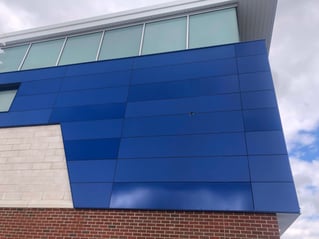 Victor central school exterior phenolic panel installation close up with three blue colors  and a exposed fastener.